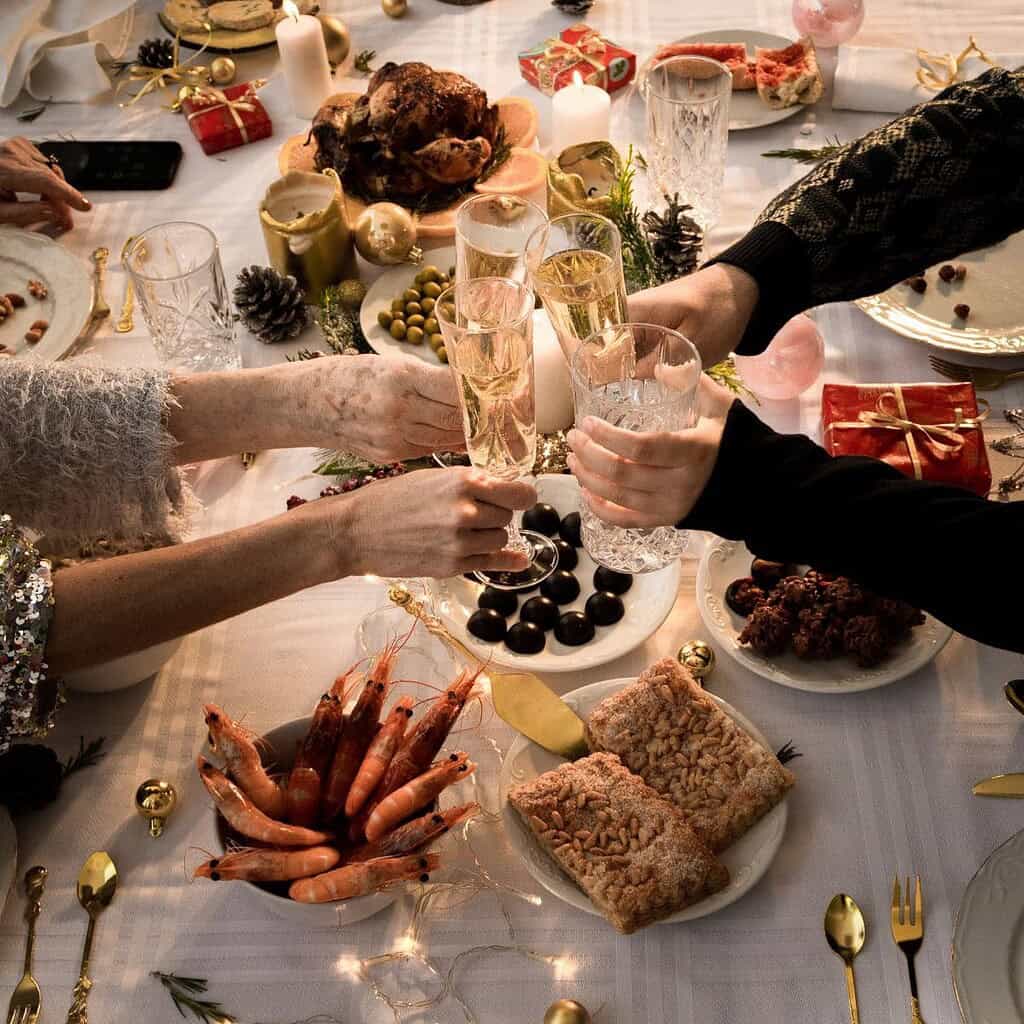 Stress in der Weihnachtszeit – Familie stoßt beim Weihnachtsessen mit Sekt an