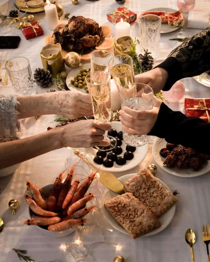 Stress in der Weihnachtszeit - Familie stoßt beim Weihnachtsessen mit Sekt an